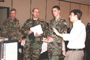 OKLAHOMA CITY  (Left to right) Col. Harmon; Tech. Sgt. Paul Gibbs, USAF, Software Engineering Process Group NCOIC, 552 Computer Systems Squadron (AWACS); Senior Airman Jonathan Overholt, USAF, software engineering process technician, 552 Computer Systems Squadron (AWACS); and Ed Hemphill, senior sales engineer, LifeSize Communications, discuss high definition video conferencing after the December chapter luncheon. 